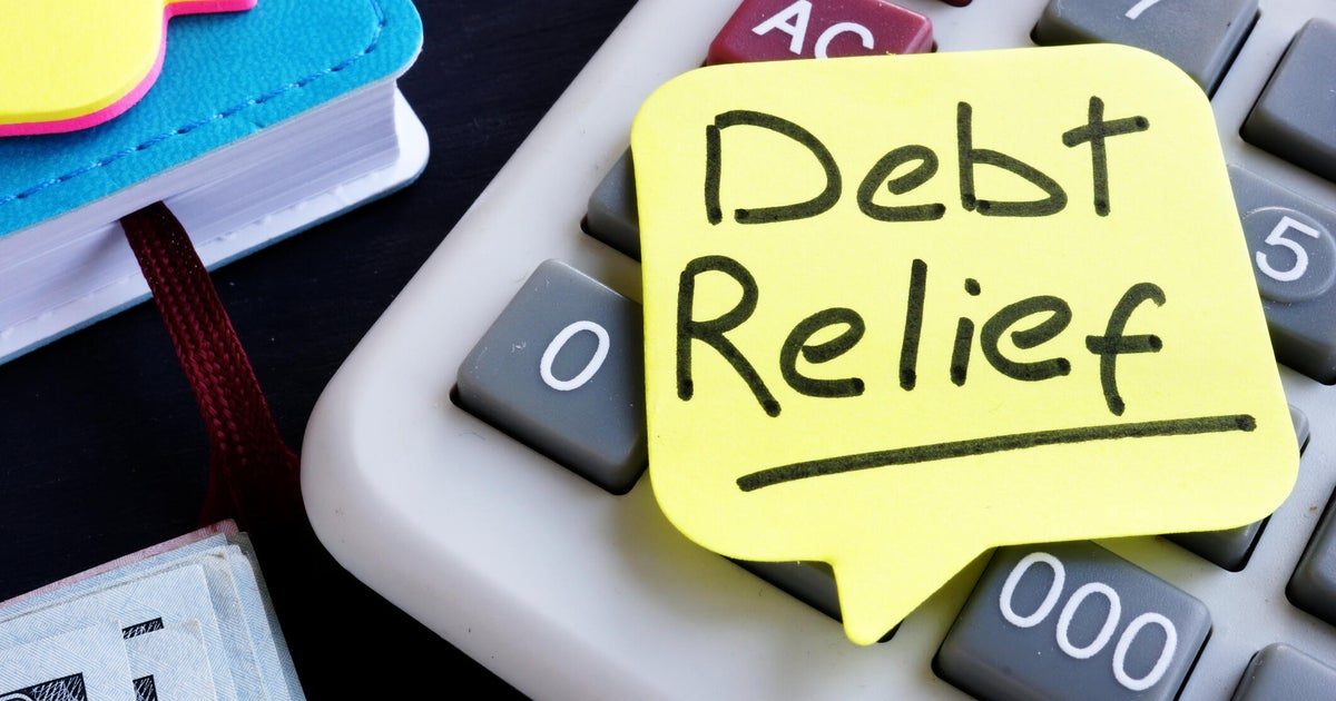 Person reviewing credit card statements and debt relief options at a desk