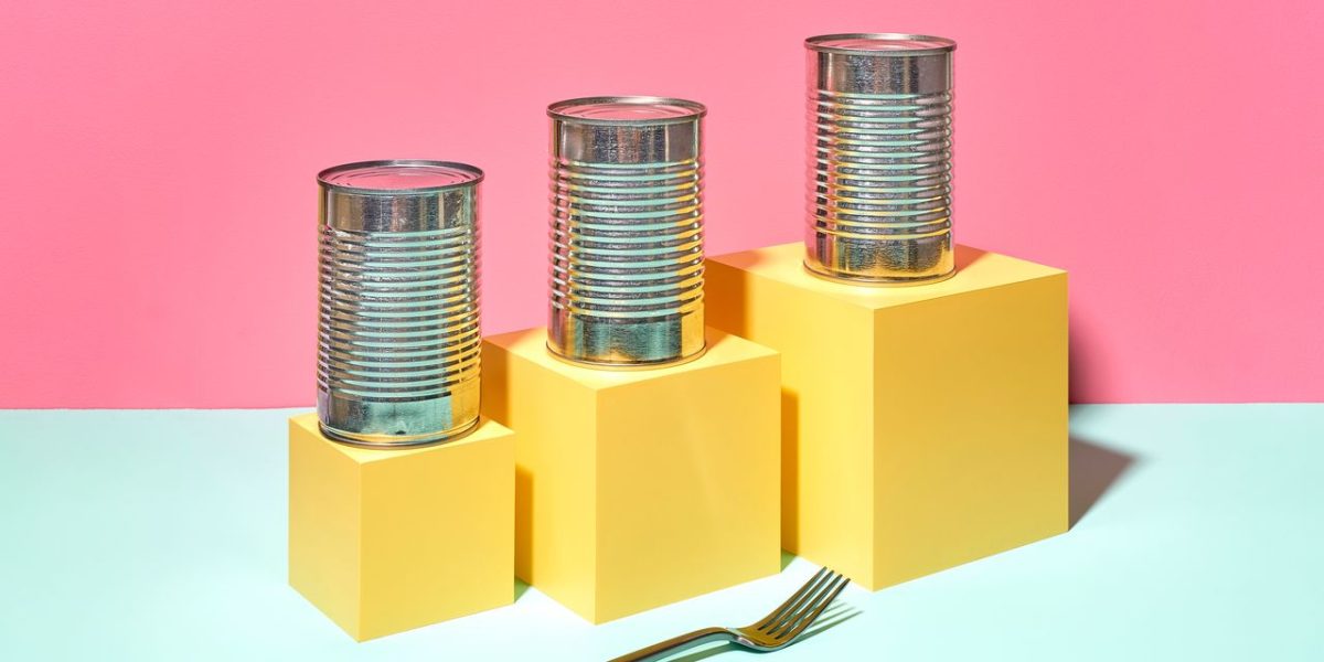 Canned vegetables and frozen produce arranged on a grocery store shelf