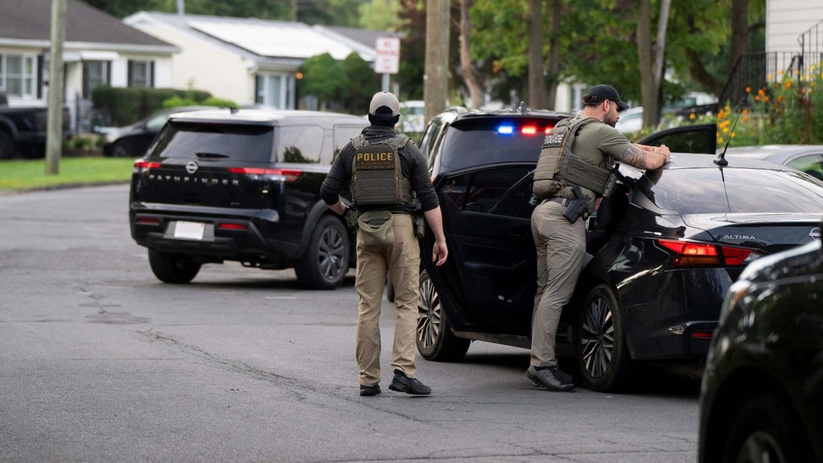 ICE agents in tactical gear stand outside a federal building in Minneapolis