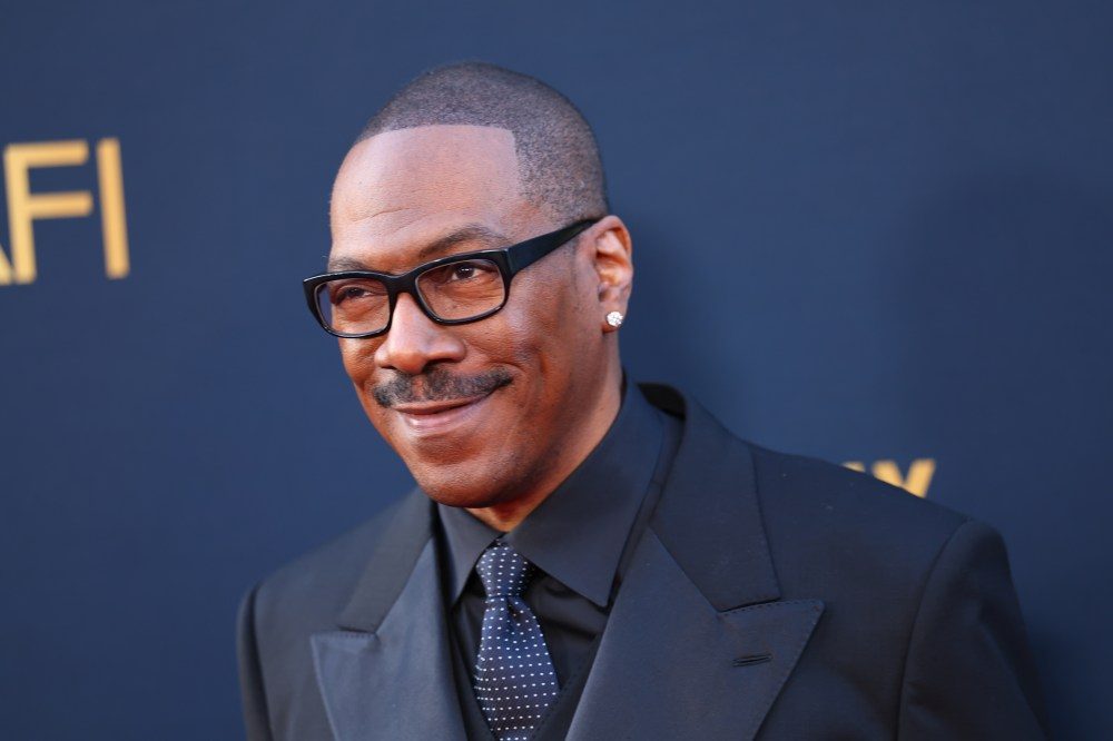 Eddie Murphy attends a red carpet event in a dark suit