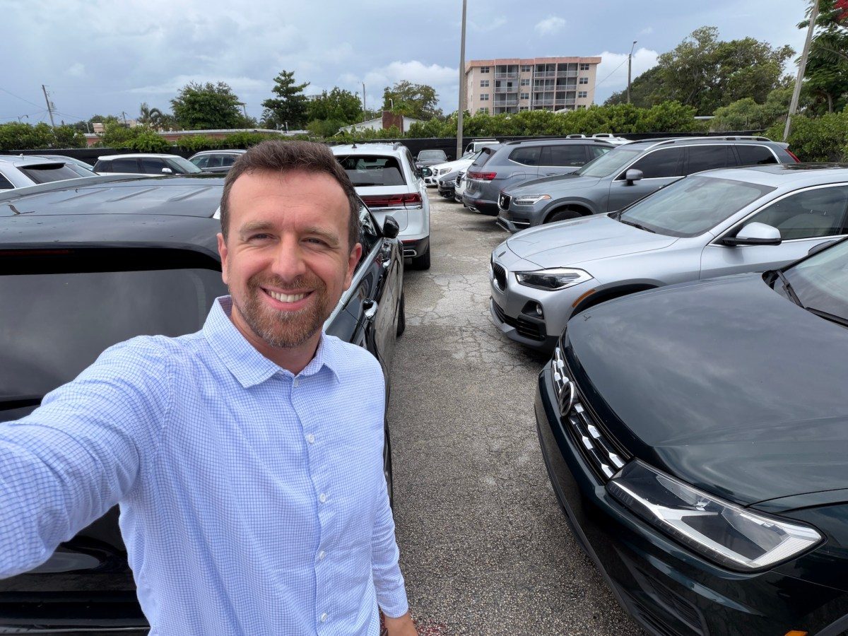 Rows of parked used cars sitting idle in a dealership lot