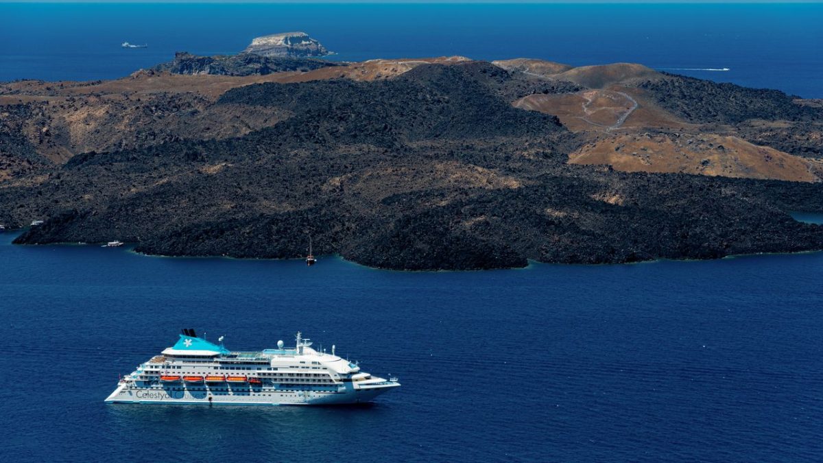 Celestyal cruise ship sailing past Greek island coastline in the Aegean Sea