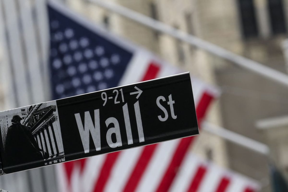 Wall Street trading floor with stock tickers showing market gains
