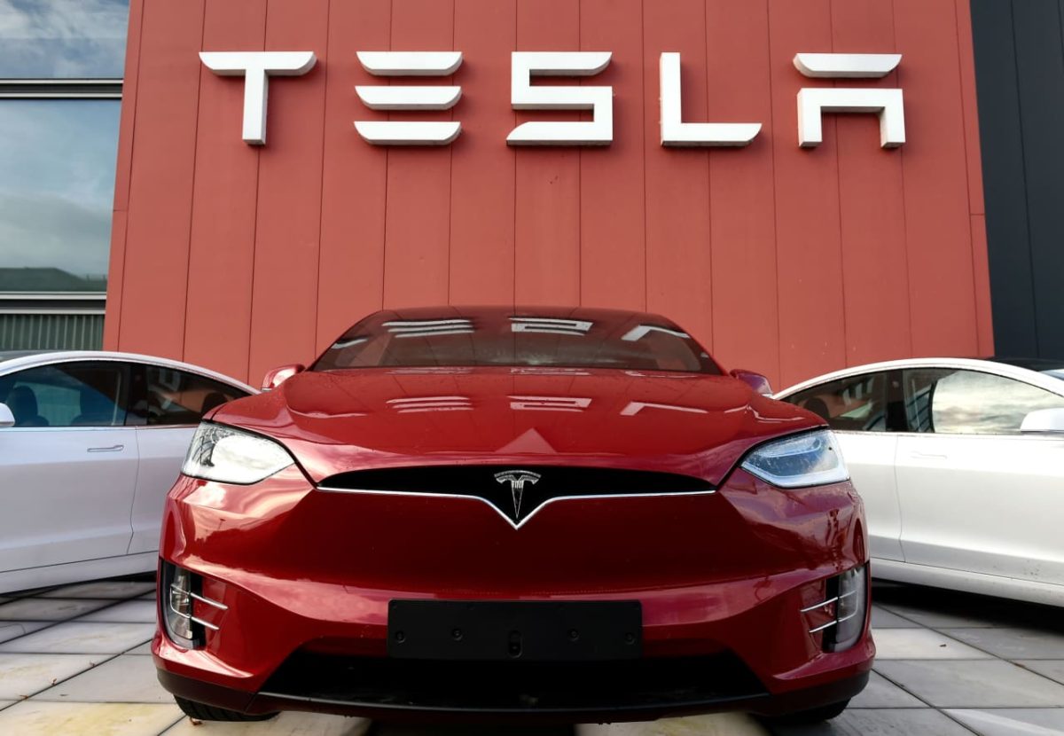 Tesla electric vehicles parked in a row outside a dealership