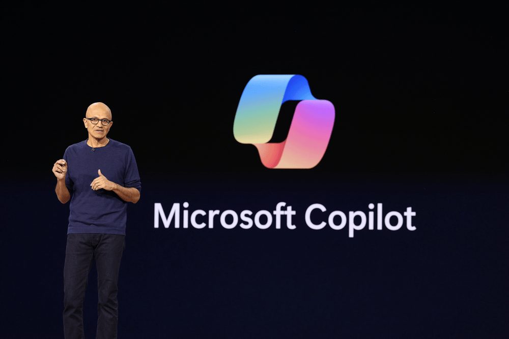 Microsoft CEO Satya Nadella speaking at a technology conference podium